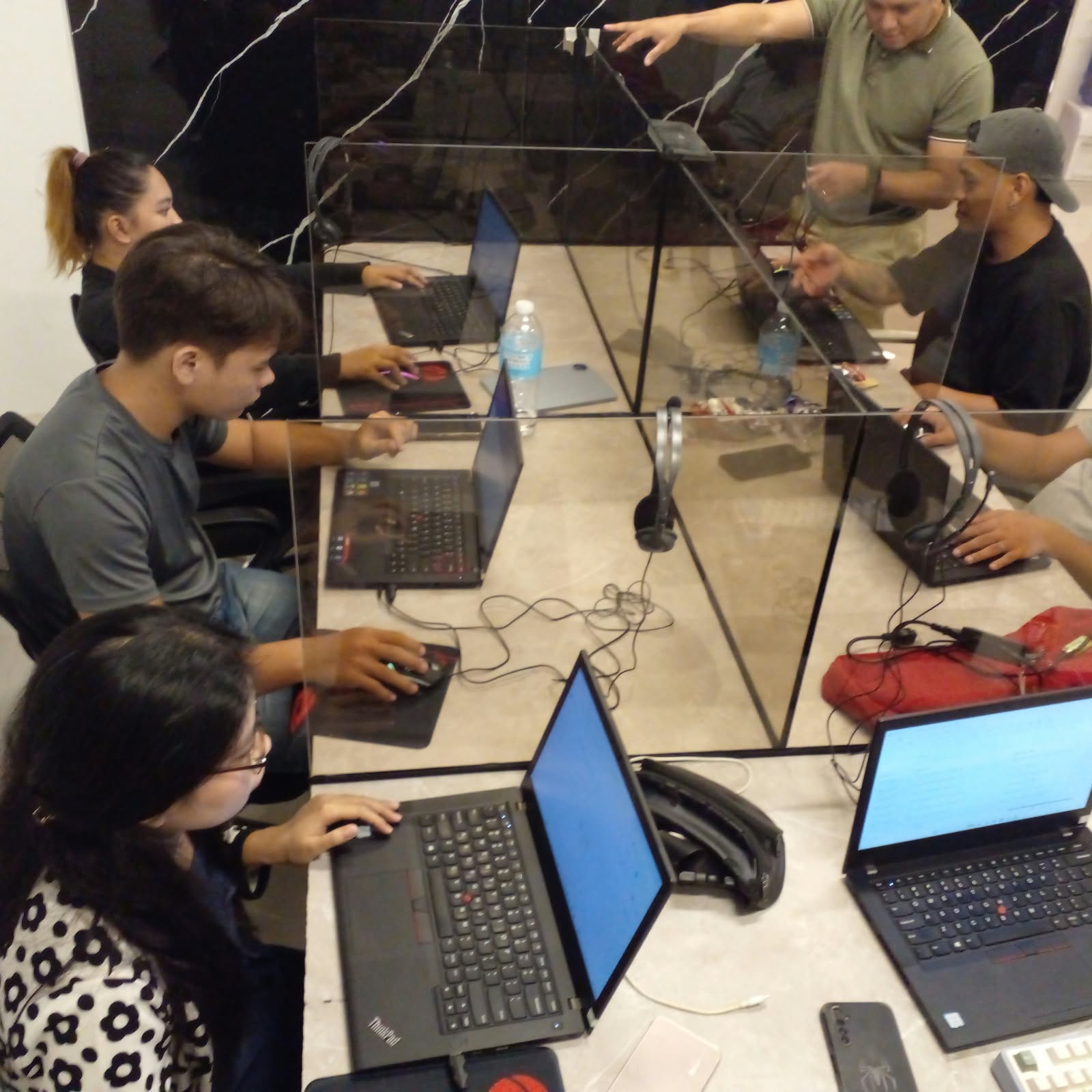 OmniXela agents working together at shared desks with glass dividers